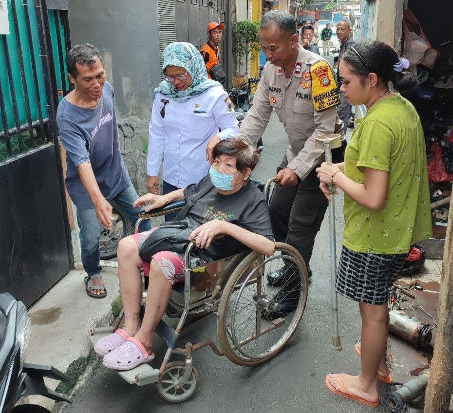 Aksi Peduli Warga Binaannya, bhabinkamtibmas Kel Maphar Bantu Dorong Kursi Roda Warga
